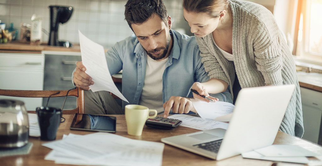 Conseiller en gestion de patrimoine et investisseur analysant des scénarios de sortie de prêt in fine avec documents de refinancement et projections temporelles
