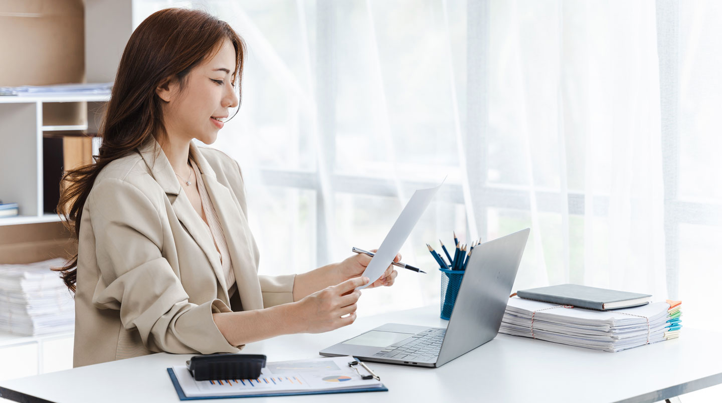 Écran d'ordinateur portable affichant un tableau Excel de simulation d'amortissement de prêt immobilier avec colonnes détaillant mensualités, capital et intérêts, personne de profil consultant les données